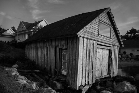 传统的挪威木屋里站在草坪和山在背景上。典型的挪威的房子。典型的挪威房子的房顶上的草