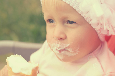 一个小女孩在吃冰淇淋和弄脏她的脸