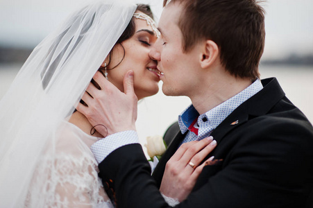 接吻的新婚夫妇，在湖边的特写照片