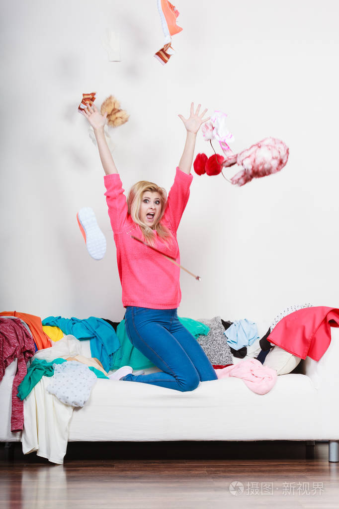 坐在凌乱的沙发上扔衣服的女人
