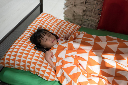 在绿色的床上睡觉的可爱亚洲女孩