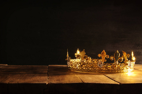 美丽的女王超大冠在木桌的低键。老式过滤。幻想中世纪时期