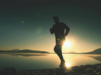 男孩很快跑在早晨的海滩上.运动员跑步,跑步的家伙照片