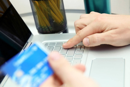 输入数据的一张信用卡的商人。网上购物在互联网上使用一台笔记本电脑