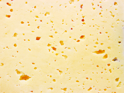 带洞的新鲜黄色瑞士奶酪的背景