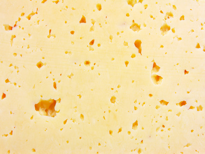 带洞的新鲜黄色瑞士奶酪的背景