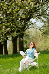 年轻女子在春天的花树下放松