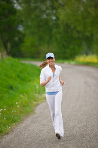 慢跑运动的女人在大自然的道路上奔跑