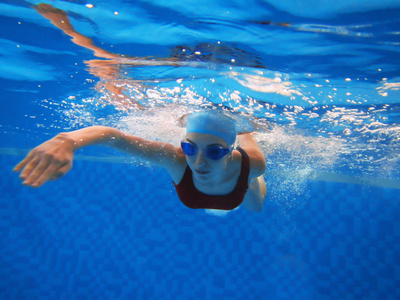 在游泳池中游泳的女人照片