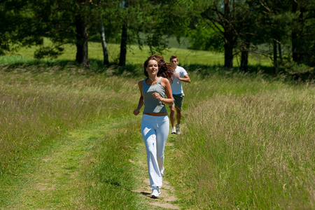 年轻夫妇在春天自然的户外慢跑