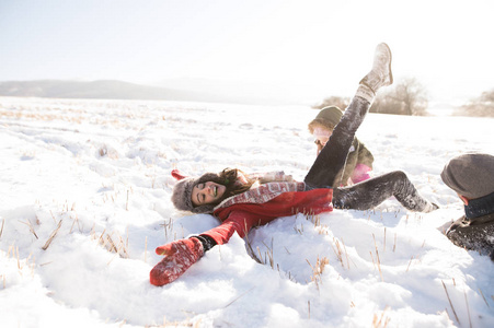 父亲和母亲带着他们的女儿，在雪地里玩