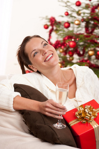 微笑的圣诞礼物的女人和香槟杯