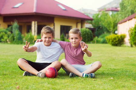 两个男孩在踢足球在校园期间玩乐
