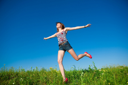快乐的年轻女子在田间跳跃