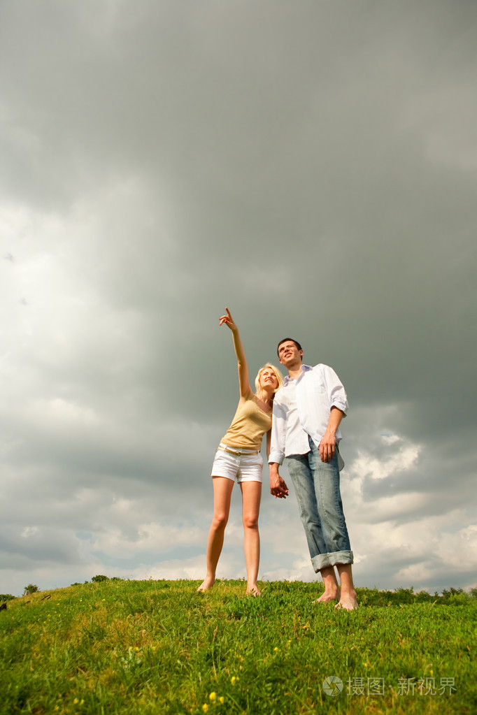 年轻的爱夫妇微笑在蓝蓝的天空下