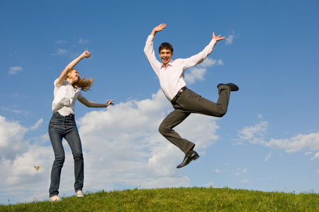 快乐的微笑夫妇在蓝蓝的天空中跳跃