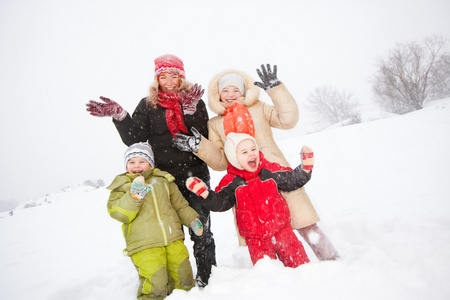 幸福的母亲和儿童一起在雪地里冷的肖像