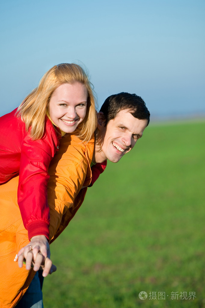 年轻的爱夫妇微笑在蓝蓝的天空下