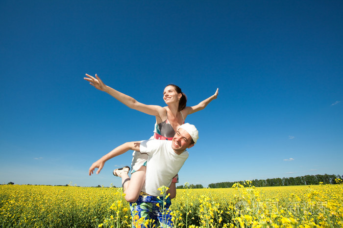 年轻的爱夫妇微笑在蓝蓝的天空下