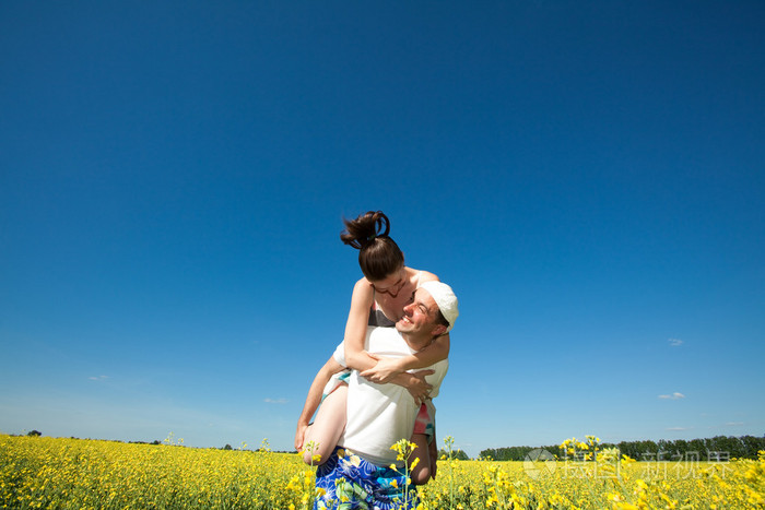 年轻的爱夫妇微笑在蓝蓝的天空下