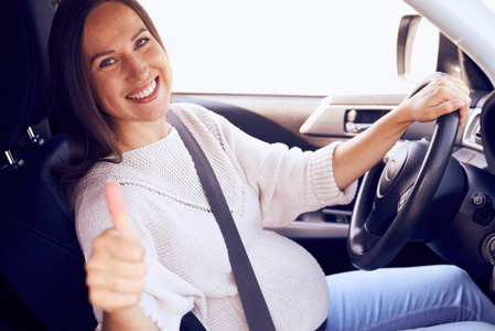 孕妇在道路上显示拇指为安全