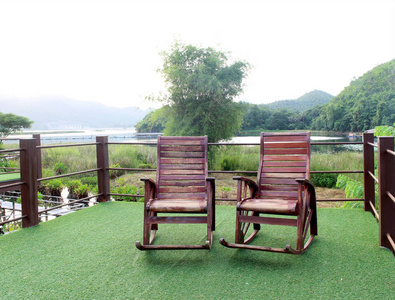 花园绿色草地上的木质摇椅