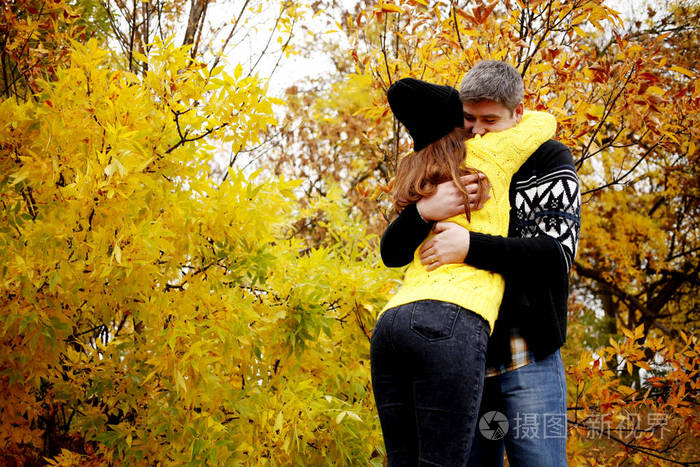 夫妇在暖和的衣服在公园中拥抱