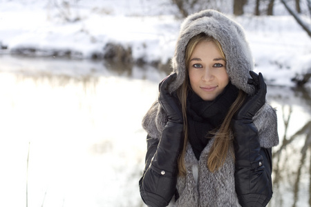 微笑的女孩走在冬天的森林里