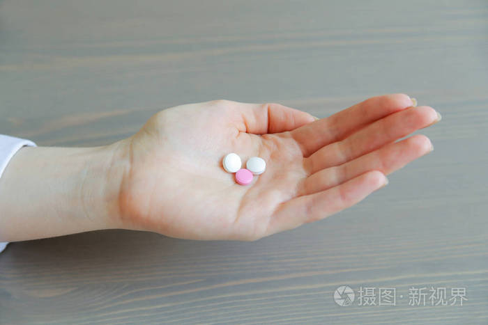 一个年轻的女人手中的药丸