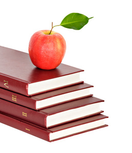 白色背景的书堆上的红苹果