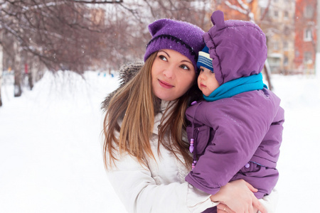 冬天的一天，一个幸福的家庭，妈妈和婴儿雪园散步