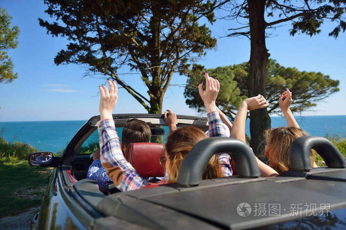 休闲自驾游旅行和人们的观念快乐的朋友开敞篷跑车车沿着乡间小路