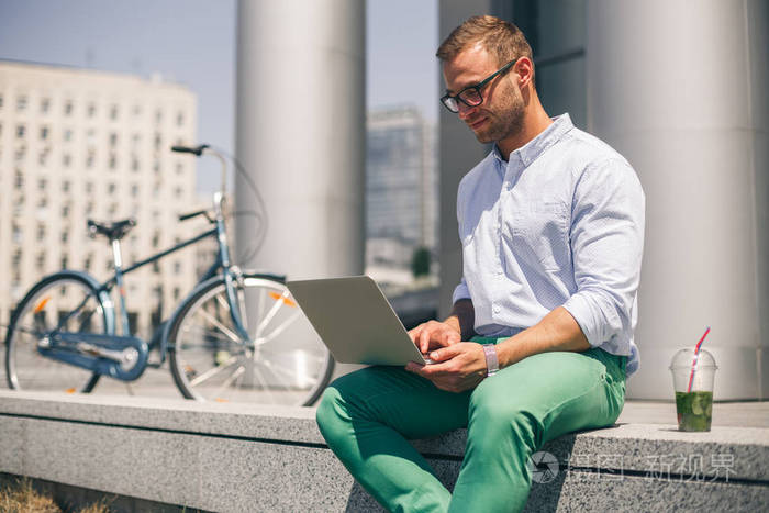 忙着快乐的人,在公司办公室外的笔记本电脑上工作照片-正版商用图片