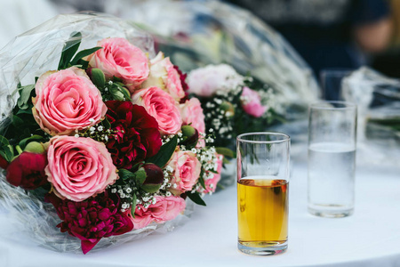 玻璃与苹果汁站粉色婚礼身后的桌子上