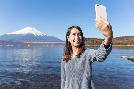 女人采取与富士山附近的手机拍照