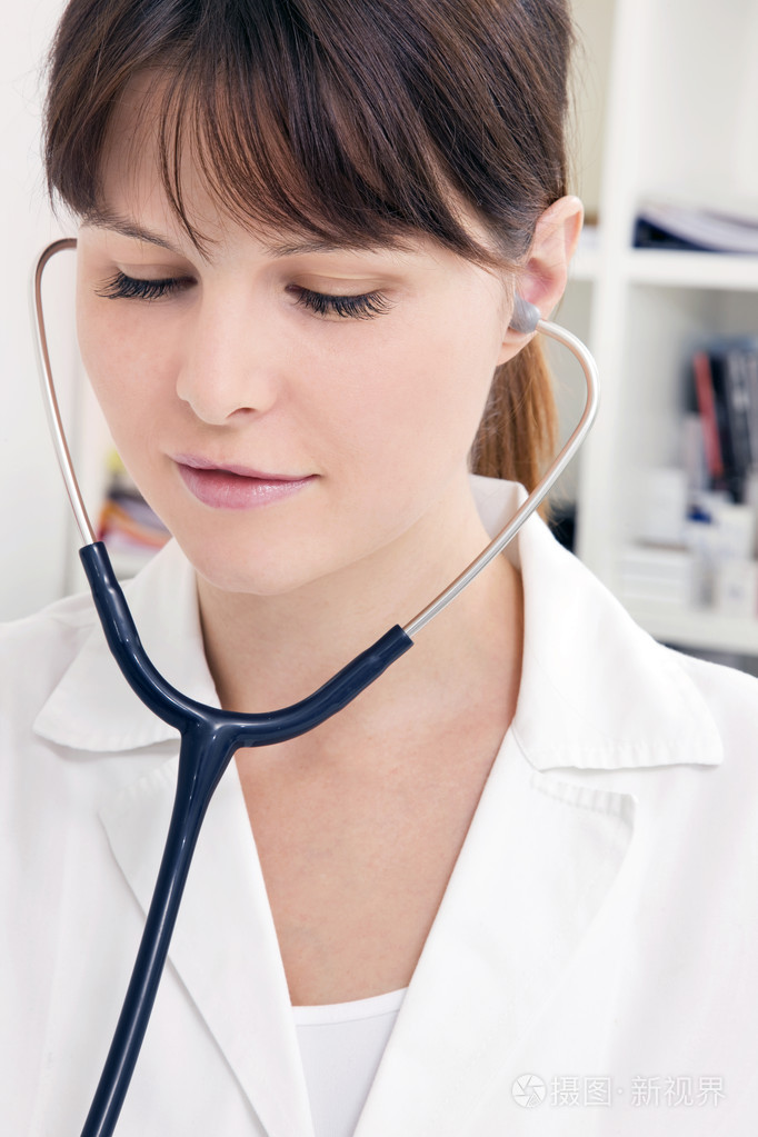 一位年轻的高加索女医生用听诊器的肖像