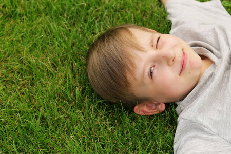 可爱的小男孩，休息在绿草夏季时间，野餐