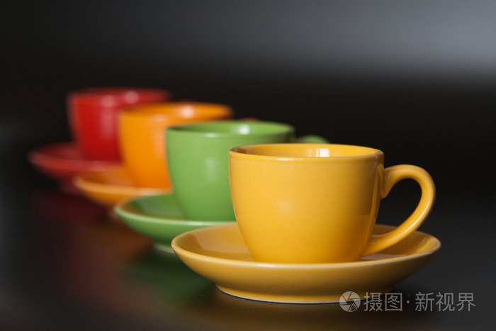 黑色背景上的四个彩色杯子