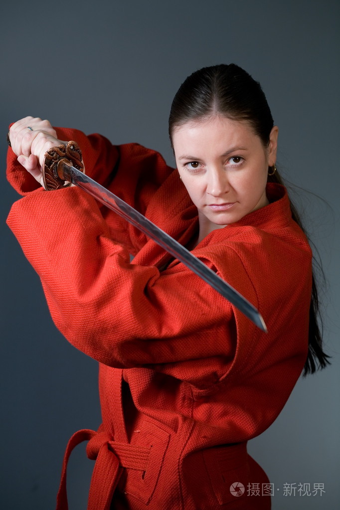 穿着红色和服带着武士刀的年轻女孩