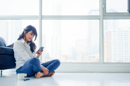 低头头发低头看着手机的年轻女人照片