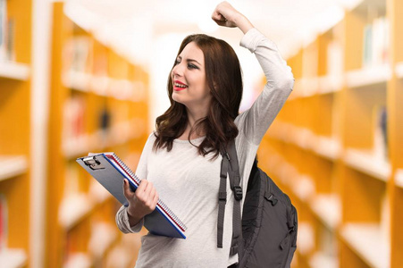 幸运的学生在图书馆中的女人