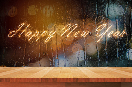 文本愉快的新年在褐色木架子和水下落在 glas