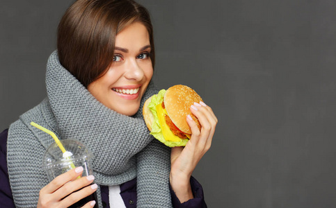 穿暖和的围巾的妇女的画像吃快餐