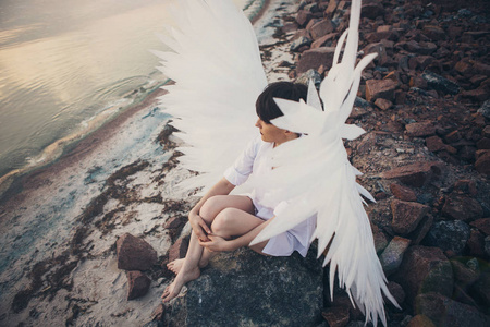 坐在河边的白色翅膀的女人