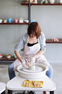 专业的亚洲波特在她的画室里创造花瓶