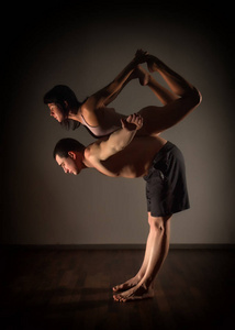 在黑暗的房间里做 acroyoga 运动的男人和女人