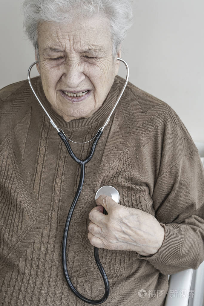 一位资深妇女用听诊器听她的心脏