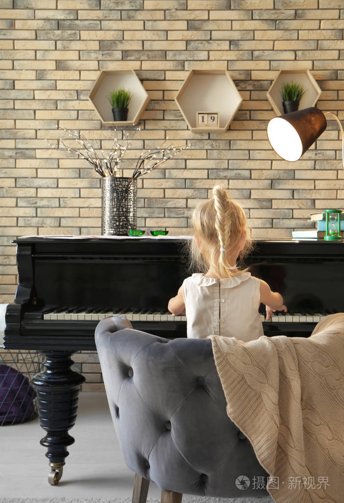在室内弹钢琴的小女孩