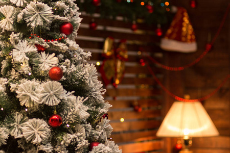 模糊的新年背景。在前台的圣诞圣诞树和圣诞老人的帽子在一个发光的台灯背景