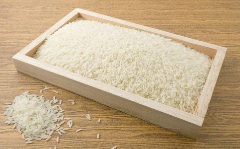籼米菜和食物, 白籼米, 香米或香米在褐色的木托盘照片